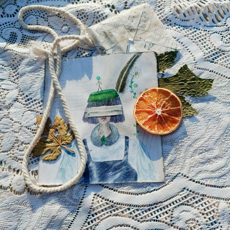 A creative still life with a surreal illustration, dried orange, and lace texture.